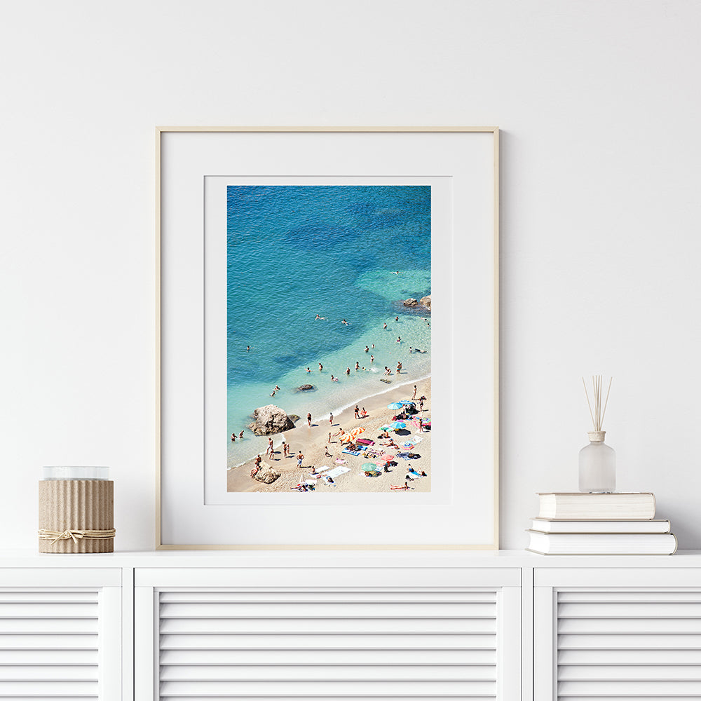 French Riviera beach print featuring the cote d'azur beach of villefranche sur mer on a summer day showing the colourful beach umbrellas and the beach goers enjoying the sun and sea by photographer Millie Brown