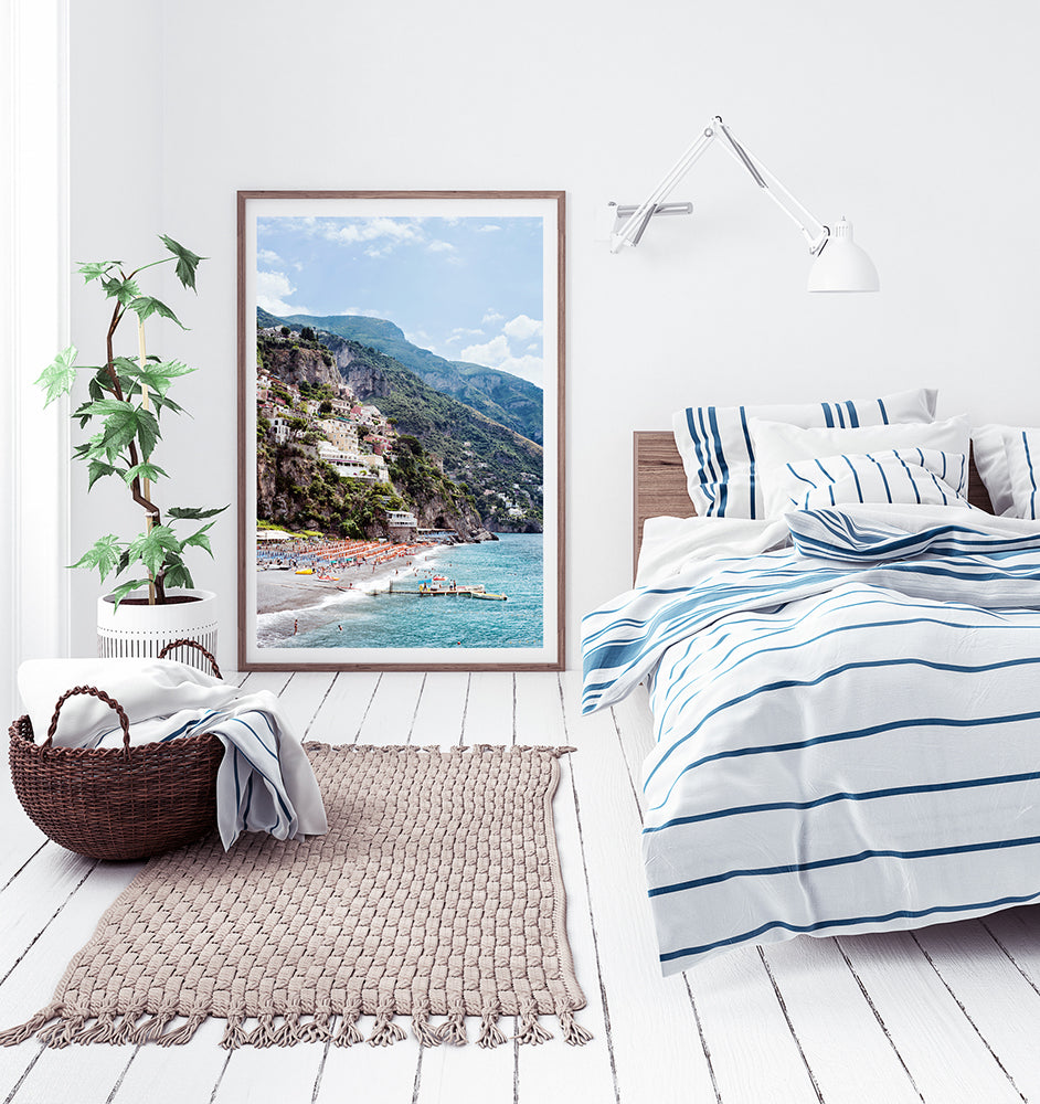 Amalfi coast photographic print featuring the Positano beach Spaggia Grande, the village, houses, the cliffs, the orange beach umbrellas and the jetty and blue mediterranean sea by Millie Brown