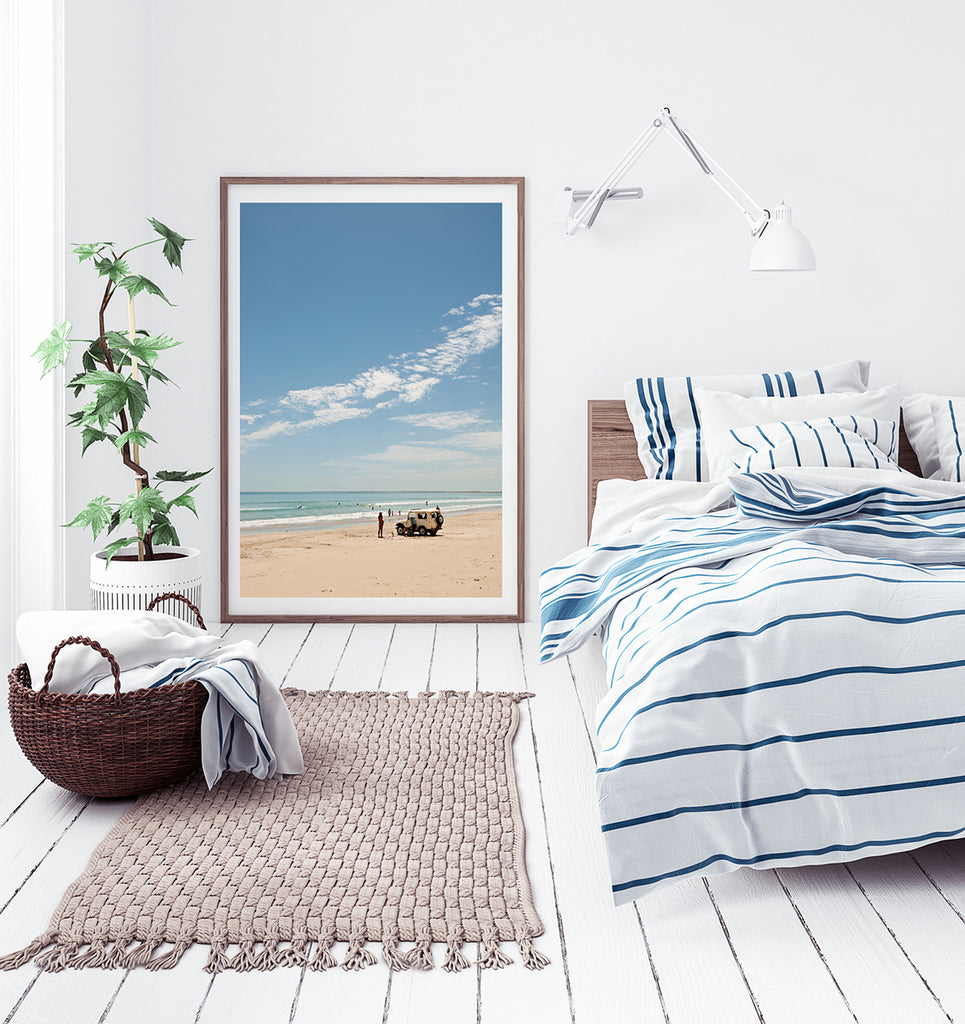 Beach wall art featuring a beautiful Australian beach with white sand and clear blue ocean with a land rover parked on the beach and beachgoers enjoying their day in the water and on the beach