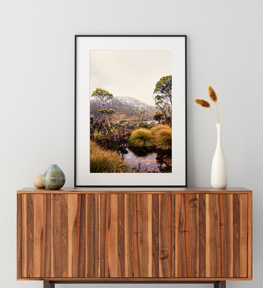 Cradle Mountain limited edition print of Cradle Mountain National Park in Tasmania featuring a beautiful mountain stream surrounded by buttongrass and bushland with dove lake in the background along with snow capped mountains by Photographer Millie Brown