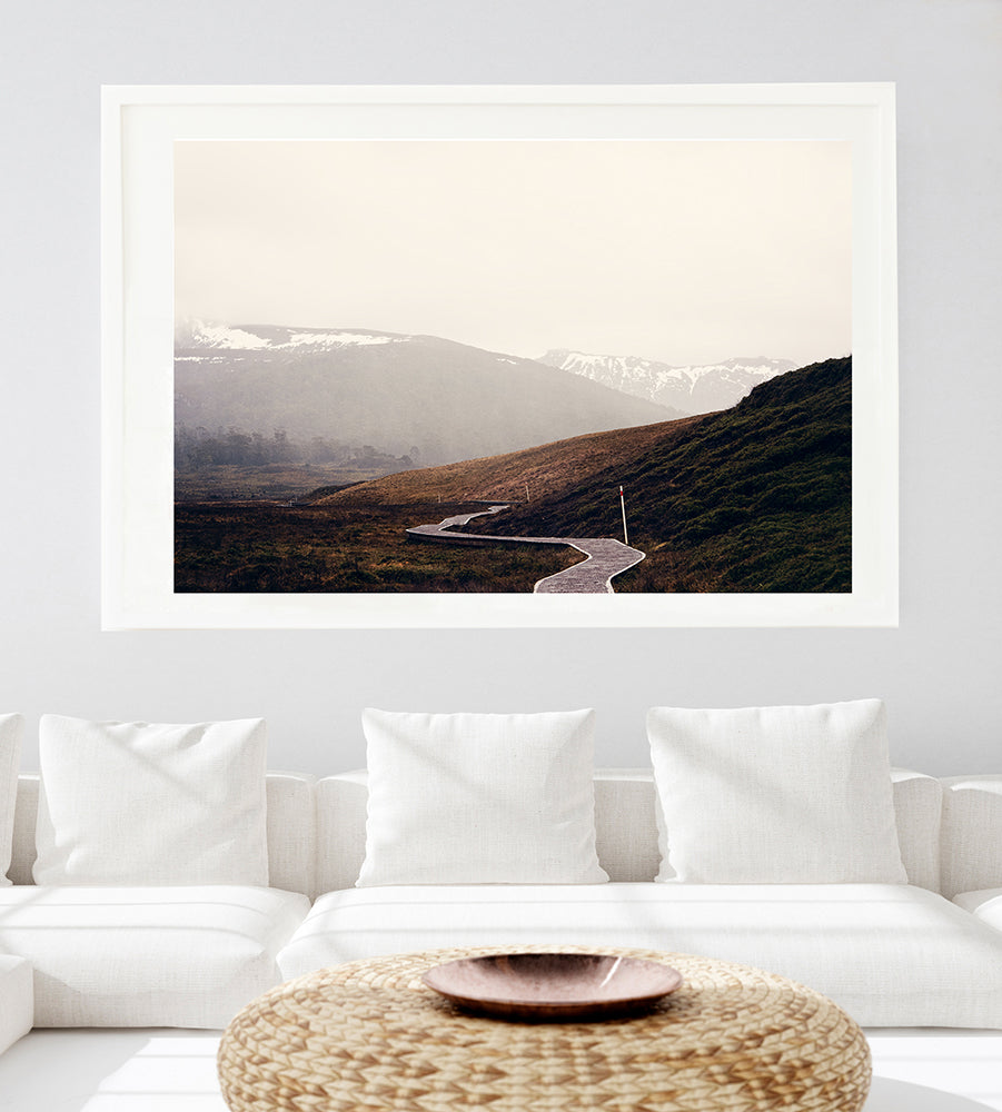 Tasmanian wall art featuring Cradle Mountain fine art prints of the stunning Tasmanian wilderness. This limited edition photographic print features the iconic overland track meandering its way through Cradle Valley and beyond with the snowy mountains in the back ground, by Millie Brown travel Photographer