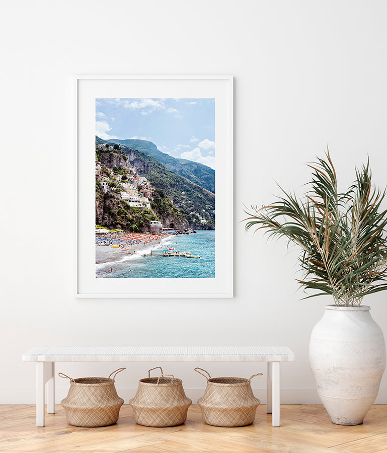 Amalfi coast photographic print featuring the Spaggia Grande Beach in Positano, the village, houses, the cliffs, the orange beach umbrellas and the jetty and blue mediterranean sea by Millie Brown