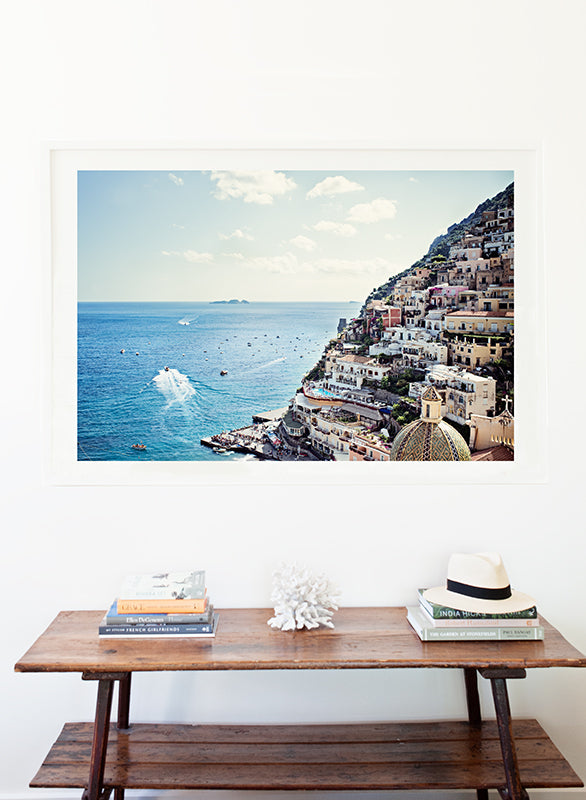 Amalfi coast wall art featuring the village of Positano and the blue mediterranean water with its small boats moving along the water and shot from above by Millie Brown