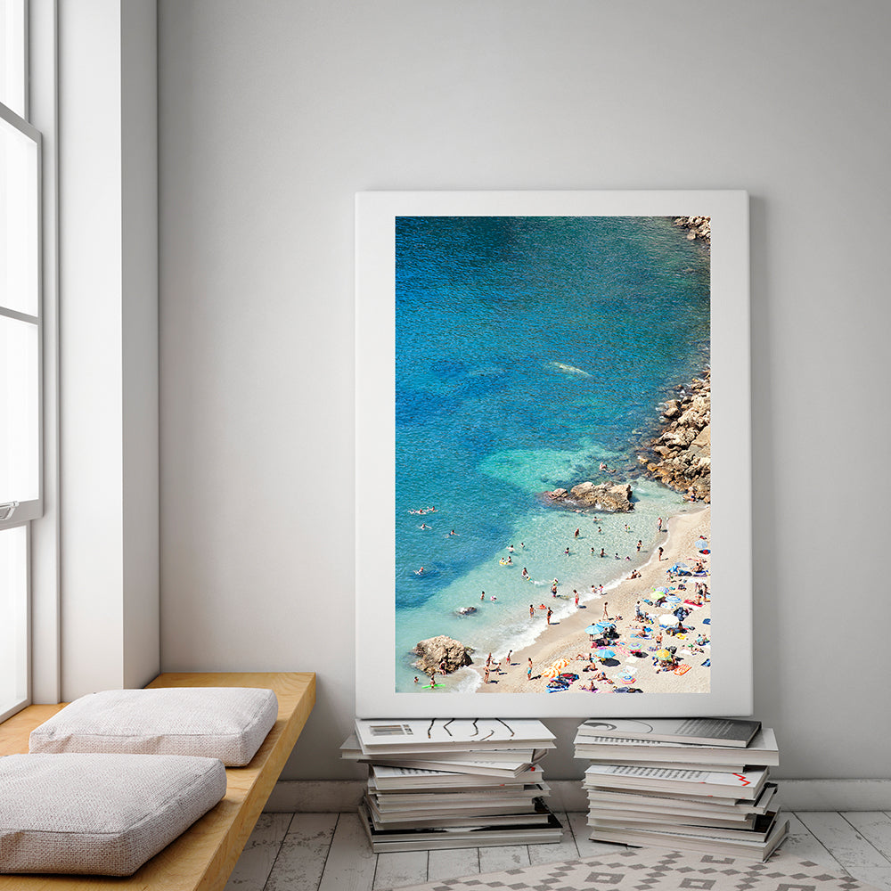 Cote d'azur beach print featuring the cote d'azur beach of villefranche sur mer on a summer day showing the colourful beach umbrellas and the beach goers enjoying the sun and sea by photographer Millie Brown